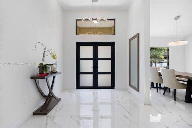 entrance foyer with marble finish floor and baseboards