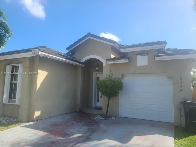 single story home with a garage, driveway, and stucco siding