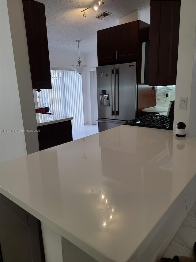 kitchen featuring a peninsula, visible vents, light countertops, stainless steel refrigerator with ice dispenser, and range