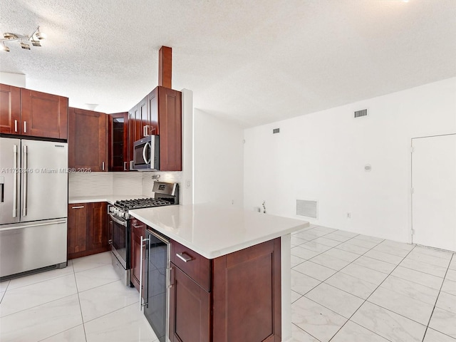 12344 SW 144th Ter, Miami, FL 33186 - kitchen featuring appliances with stainless steel finishes, wine cooler, a peninsula, light countertops, and a textured ceiling