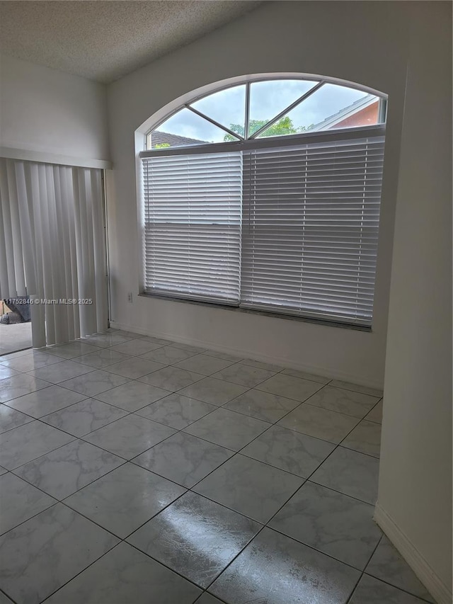 empty room featuring marble finish floor and a textured ceiling