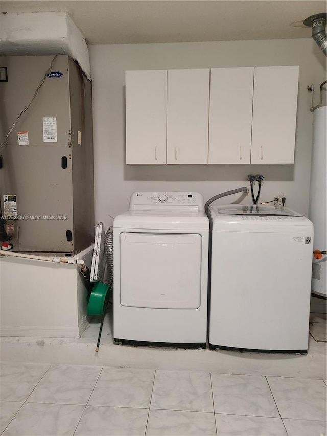 clothes washing area with washing machine and dryer and cabinet space