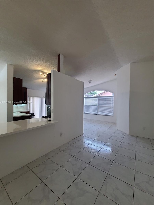 empty room featuring light tile patterned floors and a textured ceiling