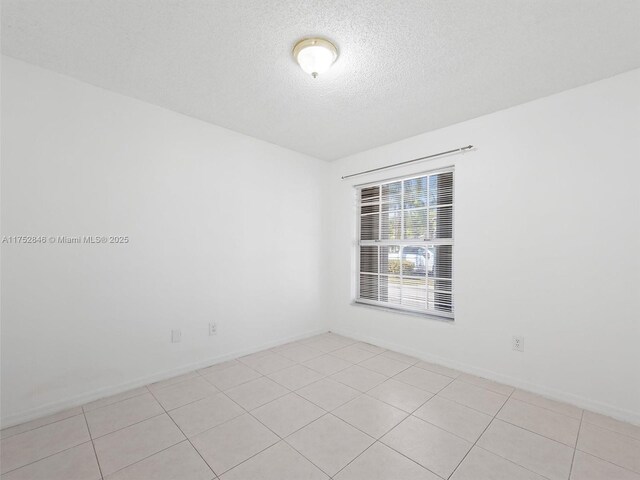 12344 SW 144th Ter, Miami, FL 33186 - unfurnished room featuring a textured ceiling, light tile patterned floors, and baseboards