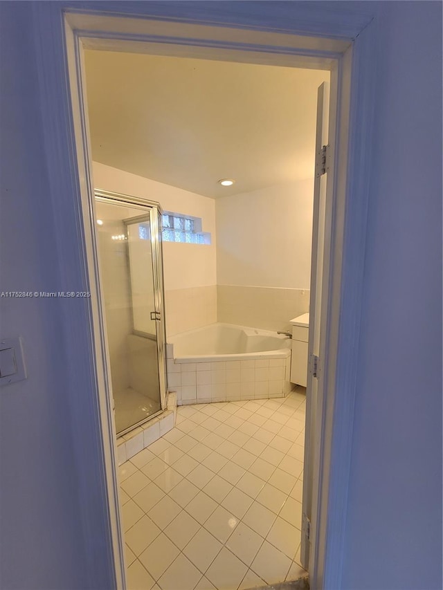 bathroom featuring a garden tub, a shower stall, vanity, and tile patterned floors