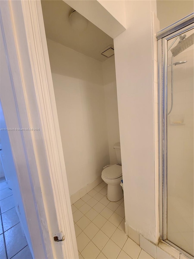 bathroom featuring baseboards, a shower stall, toilet, and tile patterned floors