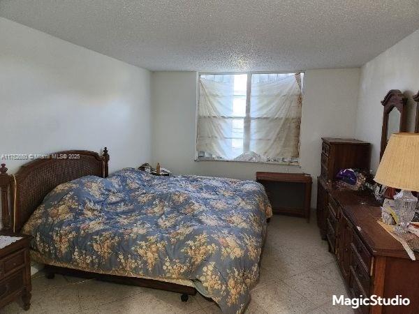 bedroom featuring light floors and a textured ceiling