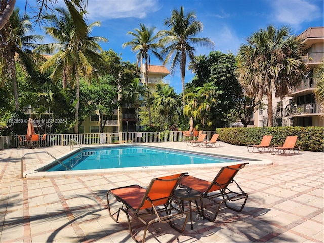 community pool featuring fence and a patio