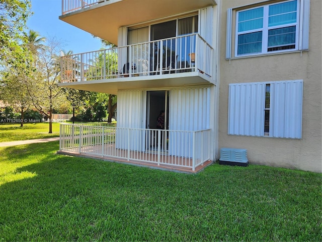 view of side of home with stucco siding and a yard