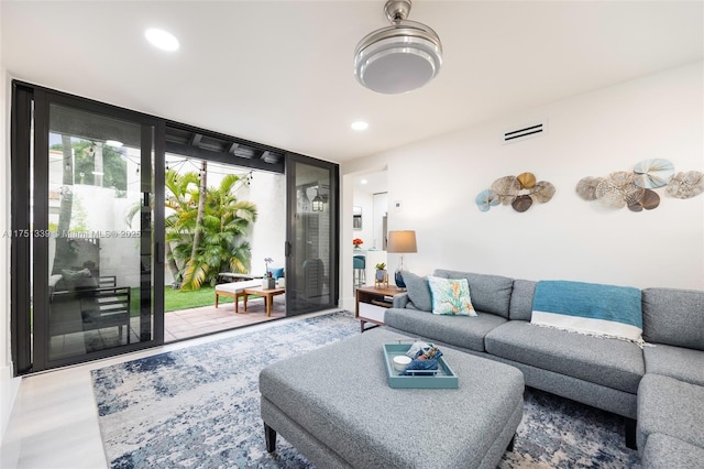 living room featuring visible vents, a wall of windows, wood finished floors, and recessed lighting