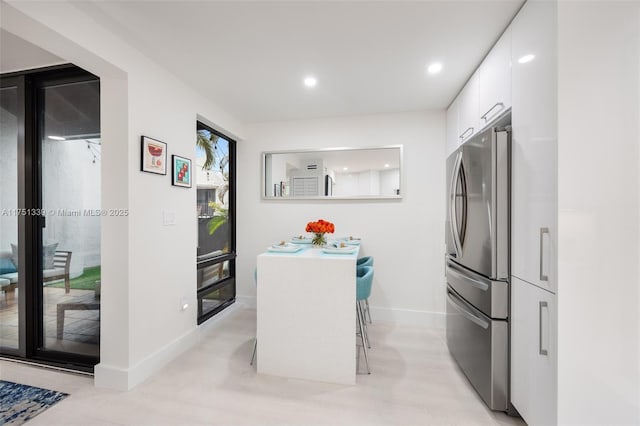 kitchen featuring freestanding refrigerator, white cabinetry, baseboards, and modern cabinets