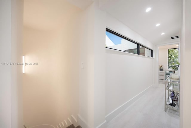 corridor with recessed lighting, lofted ceiling, and baseboards