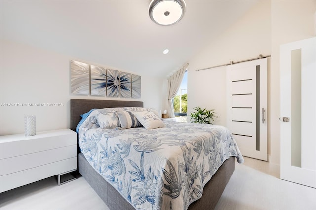 bedroom with a barn door and vaulted ceiling