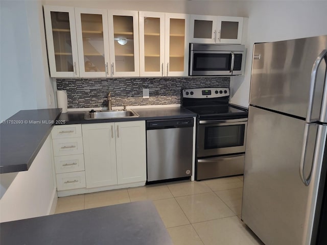 1470 NE 123rd St Unit A204, North Miami, FL 33161 - kitchen featuring appliances with stainless steel finishes, a sink, light tile patterned flooring, white cabinets, and dark countertops