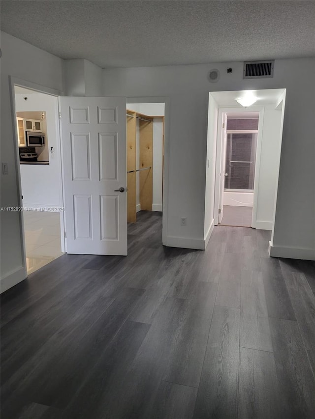 1470 NE 123rd St Unit A204, North Miami, FL 33161 - empty room with dark wood-style floors, baseboards, and a textured ceiling