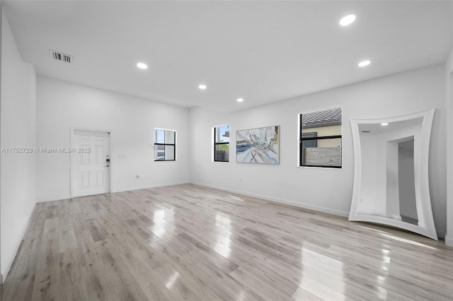 empty room with light wood-type flooring, visible vents, baseboards, and recessed lighting