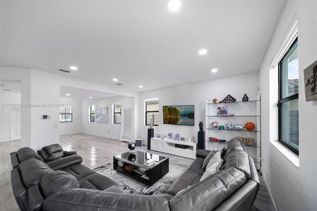 living area featuring recessed lighting, visible vents, and wood finished floors