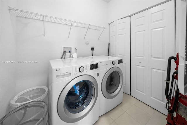 washroom with light tile patterned floors, separate washer and dryer, and laundry area