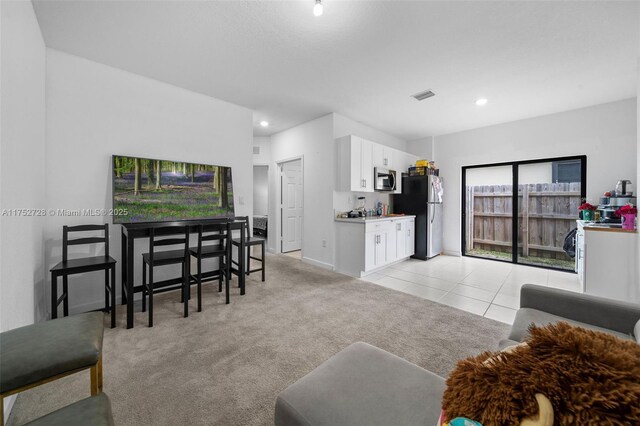 living area with visible vents, light tile patterned floors, baseboards, light carpet, and recessed lighting
