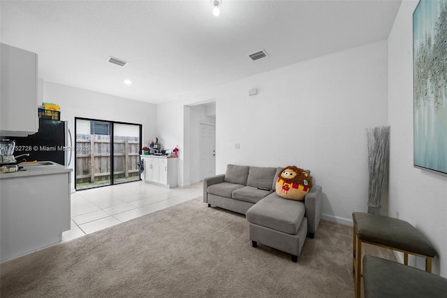 living room featuring light carpet, visible vents, and light tile patterned flooring