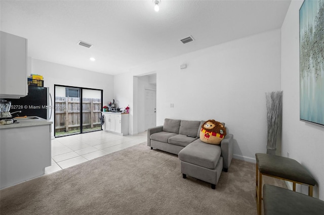 living room featuring light colored carpet, light tile patterned floors, and visible vents