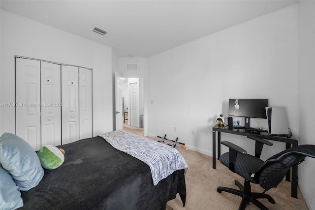 bedroom featuring baseboards, a closet, visible vents, and light colored carpet