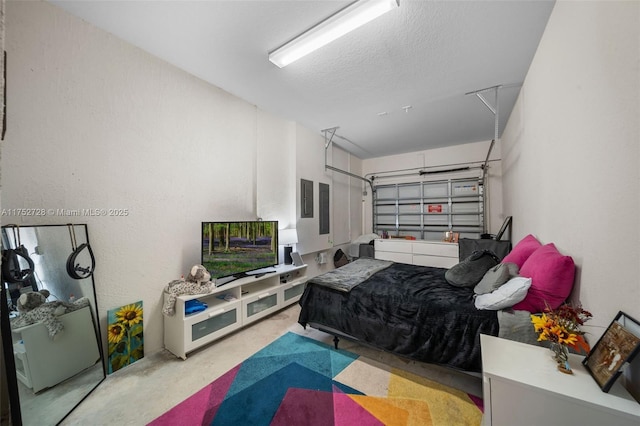 bedroom featuring a garage, concrete flooring, and a textured ceiling