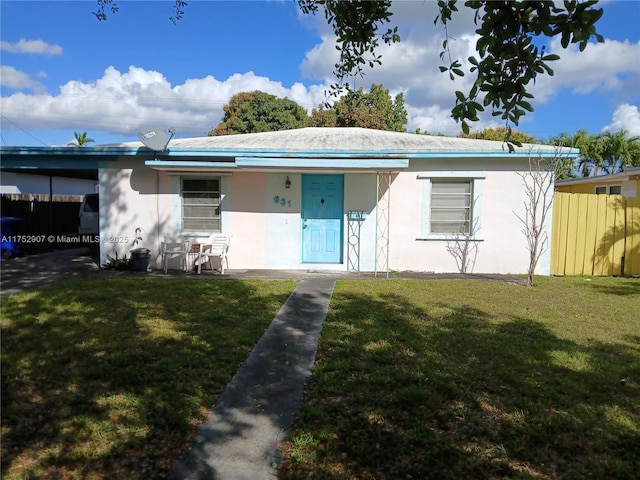 view of front of house with a front yard, stucco siding, and a carport