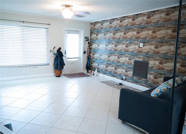 living room with visible vents, ceiling fan, baseboards, and light tile patterned floors