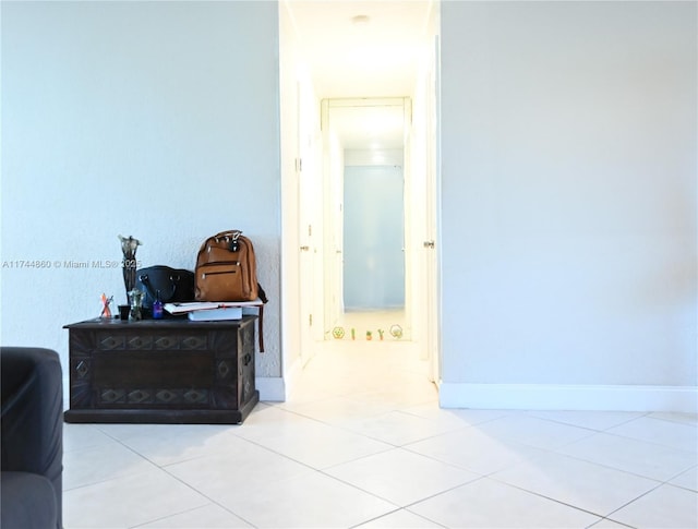 hall featuring light tile patterned floors and baseboards