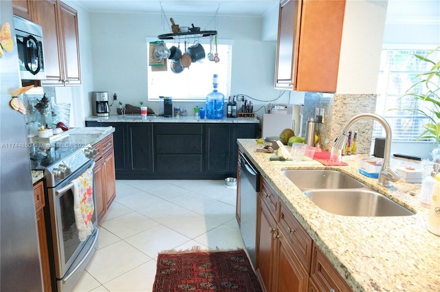 kitchen with appliances with stainless steel finishes, brown cabinetry, and a sink