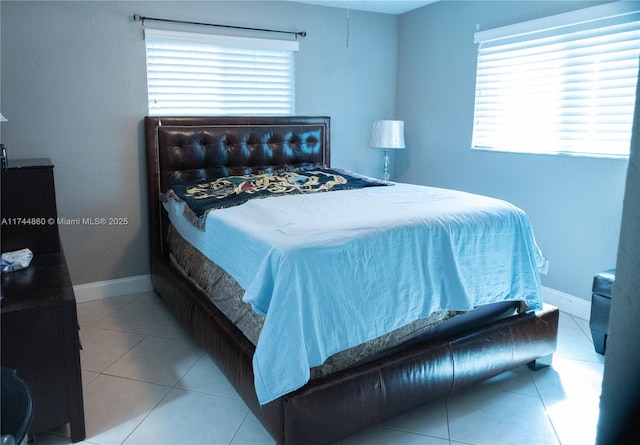 bedroom featuring light tile patterned flooring and baseboards