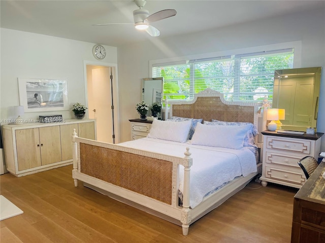 bedroom with multiple windows, ceiling fan, and wood finished floors