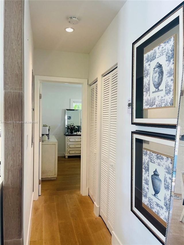 hall with baseboards, wood finished floors, and recessed lighting