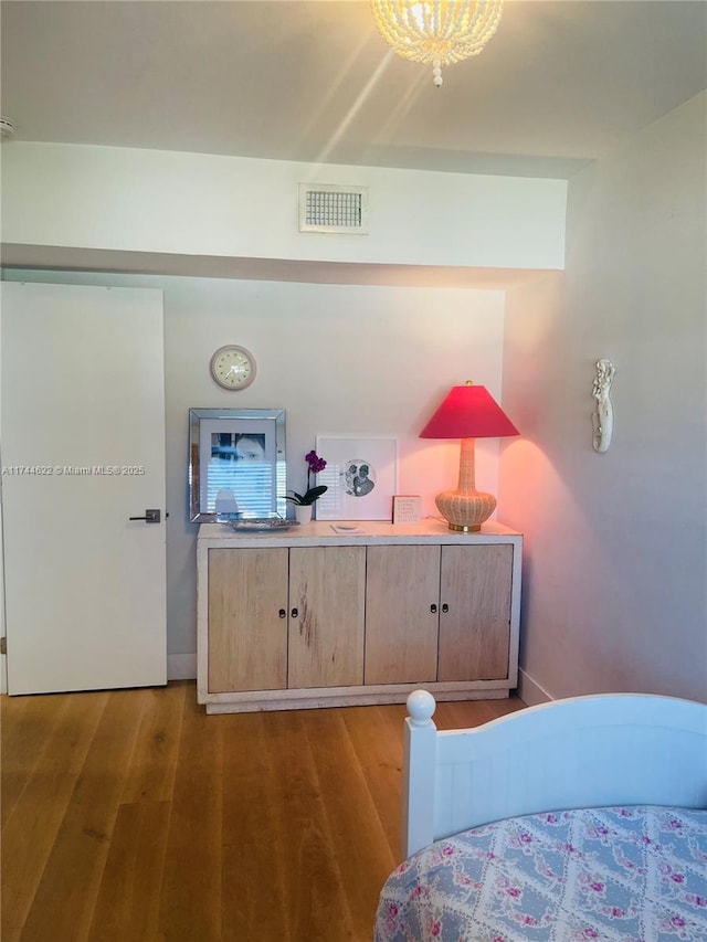 bedroom with visible vents and wood finished floors