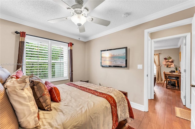 bedroom featuring ornamental molding, baseboards, a textured ceiling, and hardwood / wood-style floors