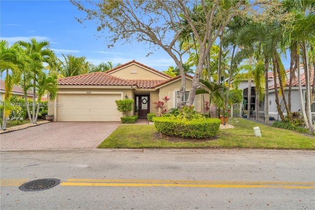 mediterranean / spanish-style home featuring a garage, a tiled roof, decorative driveway, a front lawn, and stucco siding