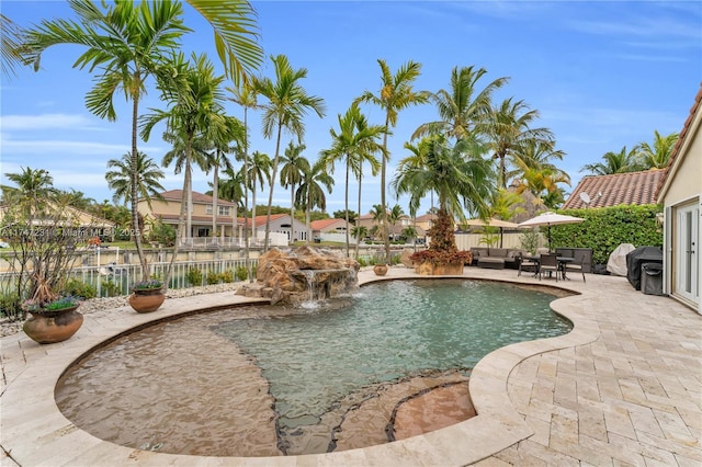 view of pool with a fenced in pool, a water view, an outdoor hangout area, a patio area, and fence