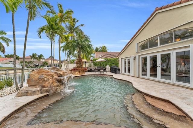 view of pool featuring a patio area, fence, a fenced in pool, and french doors