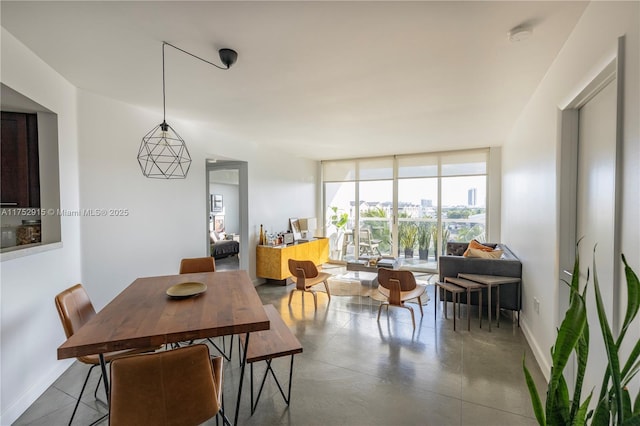 dining space with expansive windows, finished concrete flooring, and baseboards