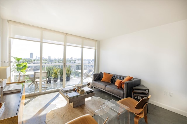 living area featuring baseboards, a wall of windows, and a city view