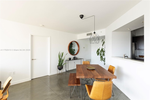 dining area with visible vents, concrete floors, and baseboards