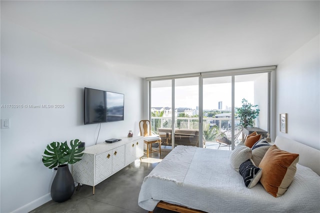 bedroom with access to exterior, baseboards, finished concrete flooring, and floor to ceiling windows