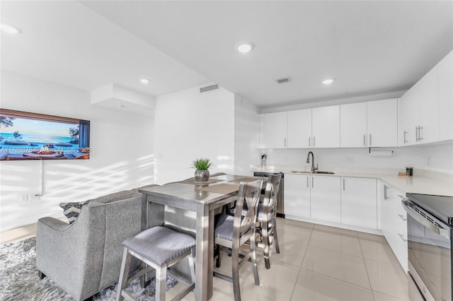 kitchen with light countertops, a sink, and white cabinetry