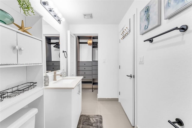 spacious closet featuring light tile patterned floors, a sink, and visible vents