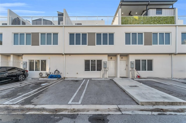 view of front of house with uncovered parking and stucco siding