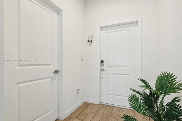 doorway with baseboards and light wood finished floors