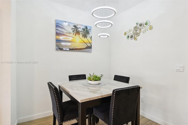 dining space featuring light wood-style floors and baseboards