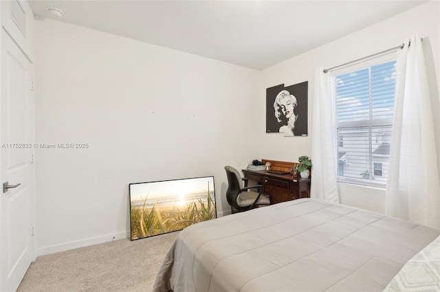 bedroom with baseboards and light colored carpet