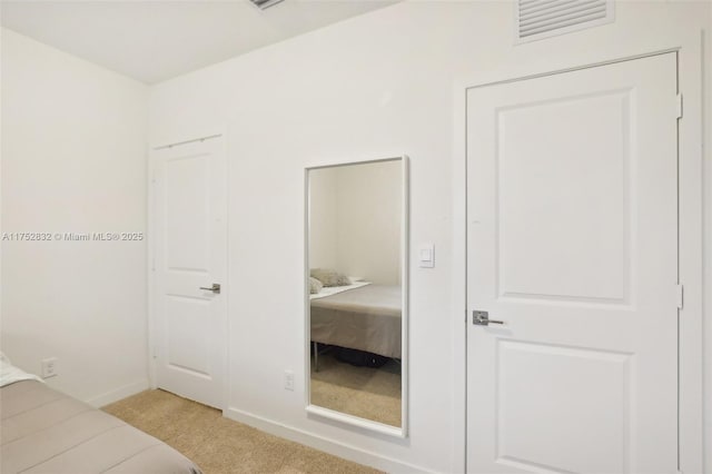 bedroom featuring light carpet and baseboards